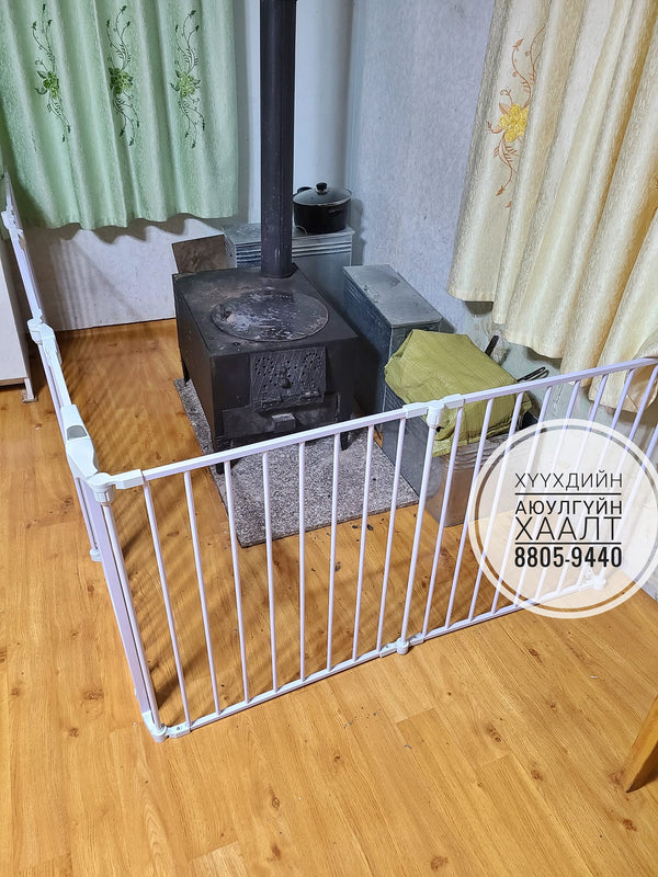 Room with a stove and white baby gate, curtains, and a phone number overlay.