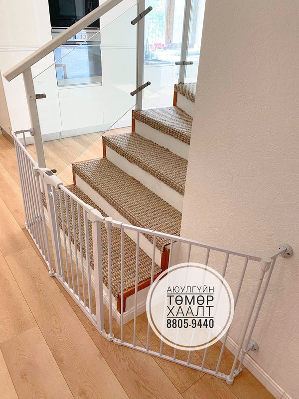 White baby gate installed at the base of a staircase in a home setting.