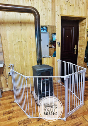 White baby gate in a room with wooden walls and a door.