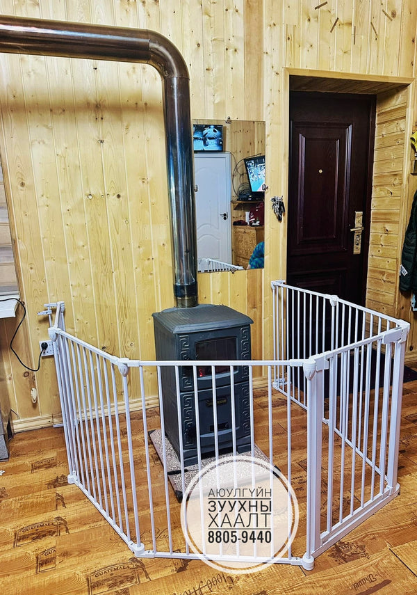 White baby gate in a room with wooden walls and a door.