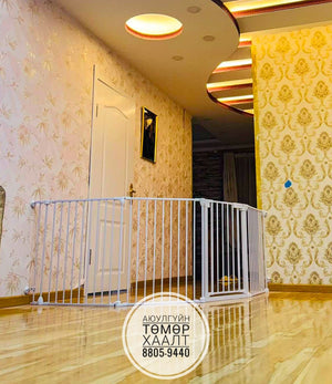 White baby gate in a room with decorative wallpaper and a door.