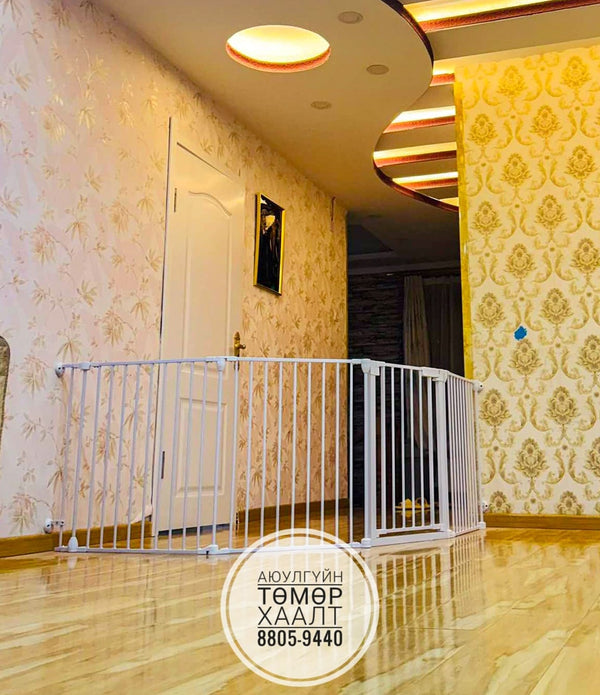 White baby gate in a room with decorative wallpaper and a door.