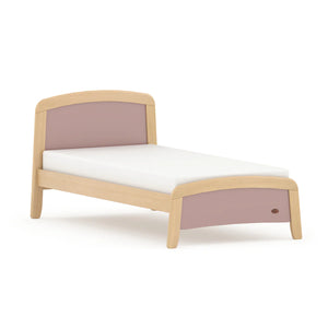 Bed with wooden frame and pink headboard on a white background