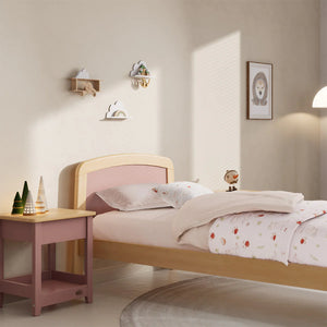 Children's bedroom with a pink and wooden bed, nightstand, and wall decorations.