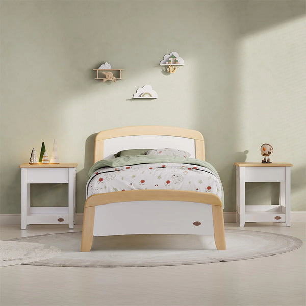 Children's bedroom with a wooden bed, white nightstands, and decorative items on a light green wall.