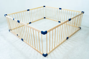 Wooden playpen with blue corners on a white background
