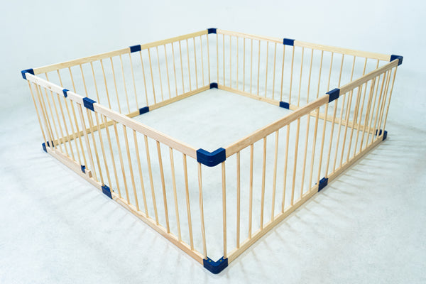 Wooden playpen with blue corners on a white background