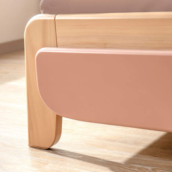 Close-up of a modern chair with pink seat and wooden legs on a light wood floor.