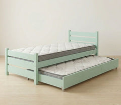 Light green bed with a mattress and pull-out trundle on a wooden floor.
