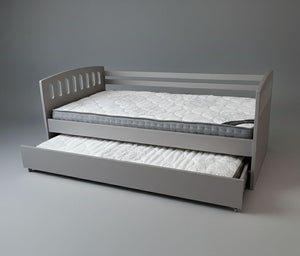Gray bed frame with a mattress and pull-out trundle on a gray background