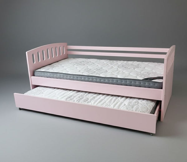 Pink children's bed with a mattress and pull-out trundle on a gray background