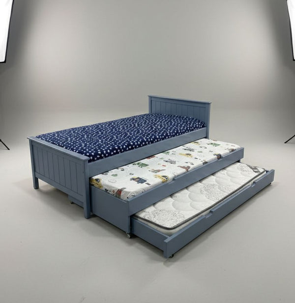Blue bed with a pull-out trundle featuring cartoon patterns on a gray background
