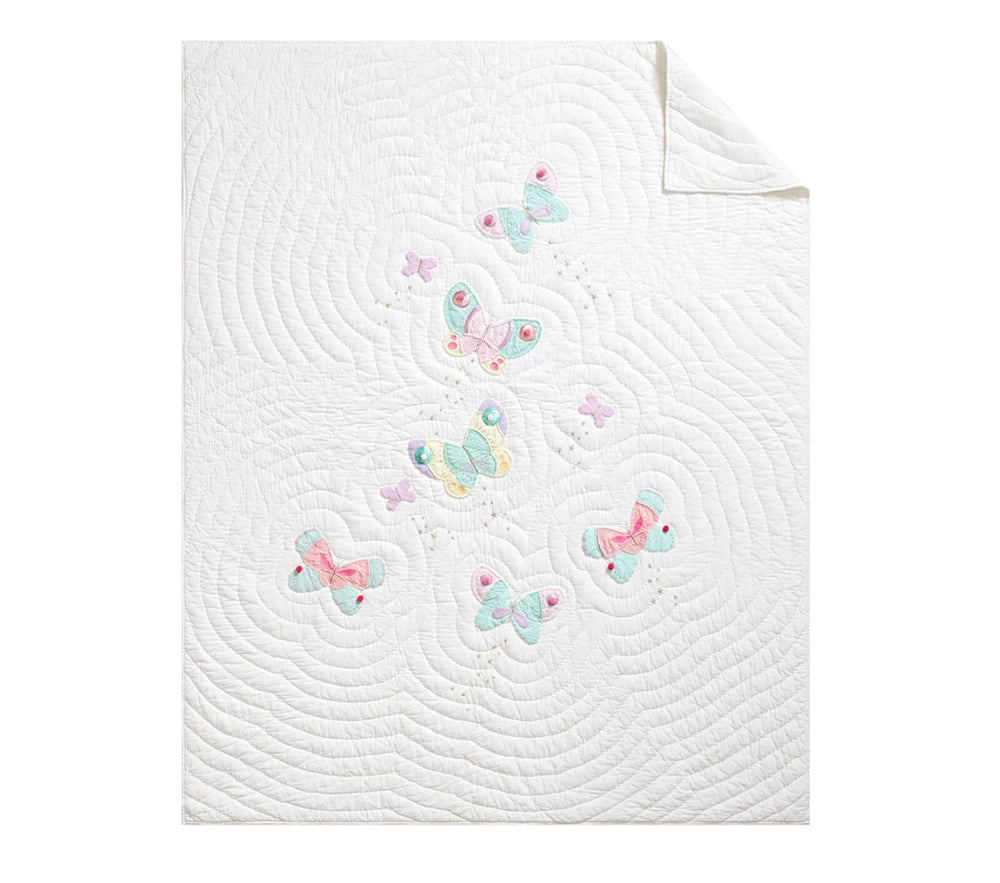 Children's bed with butterfly-themed bedding and pillows.