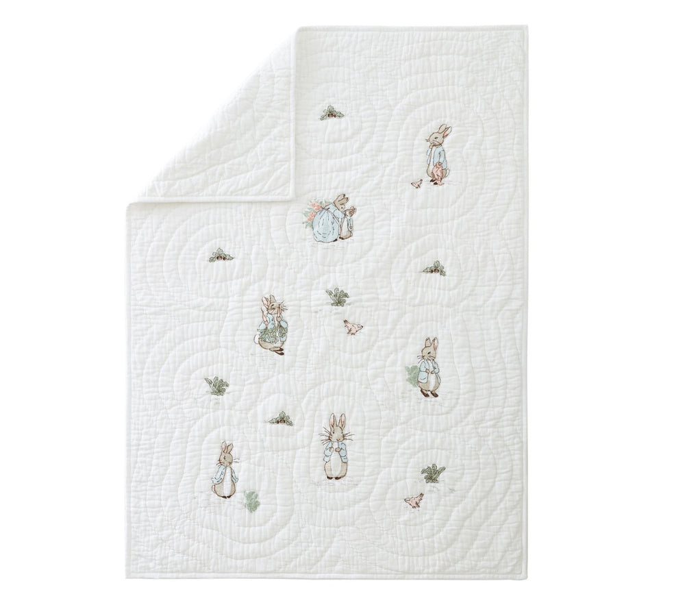 White quilt with embroidered characters on a white background