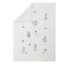 White quilt with embroidered characters on a white background