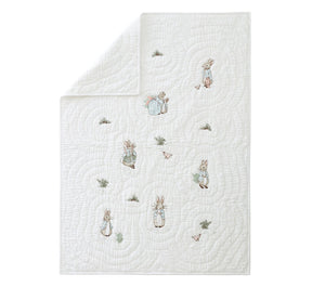 White quilt with embroidered characters on a white background