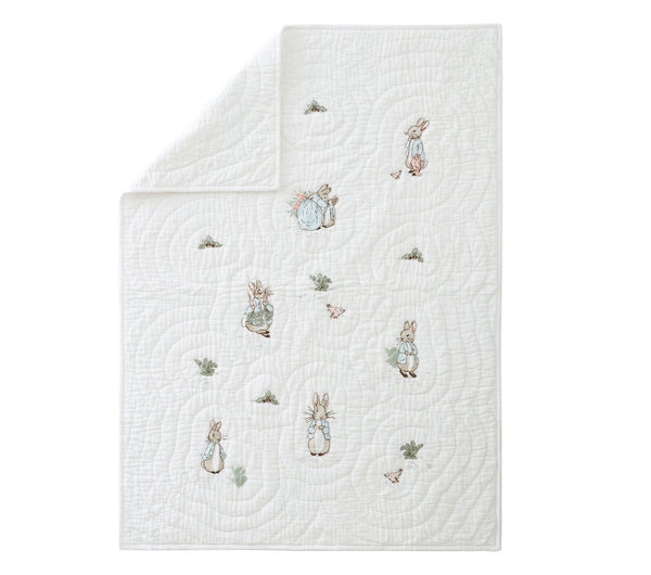 White quilt with embroidered characters on a white background