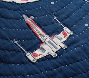 Embroidered spaceship design on a blue fabric background