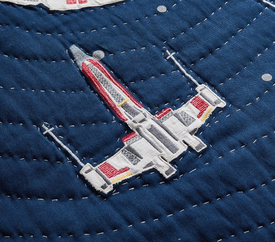 Embroidered spaceship design on a blue fabric background