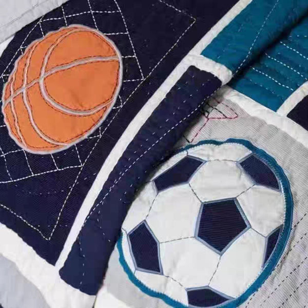 Quilt with basketball and soccer ball appliqués on a blue and white background