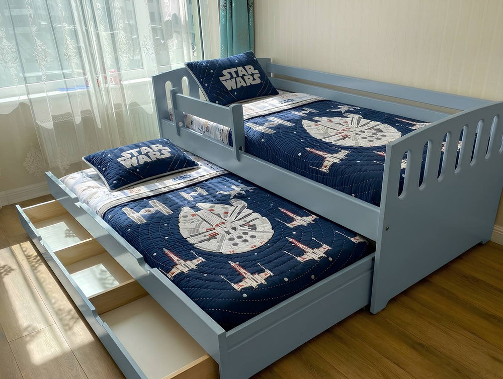 Children's bed with Star Wars bedding in a room with curtains and wooden floor.
