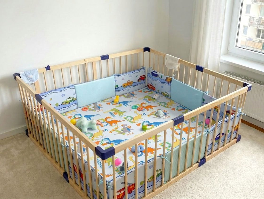 Wooden crib with colorful bedding and toys in a room with a window.