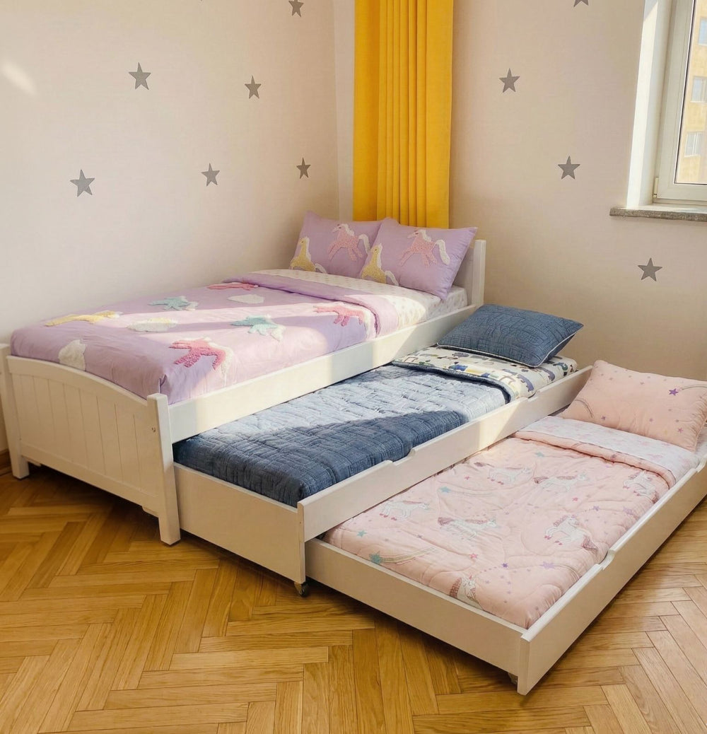 Children's bed with pull-out trundle in a room with star decals on the wall.