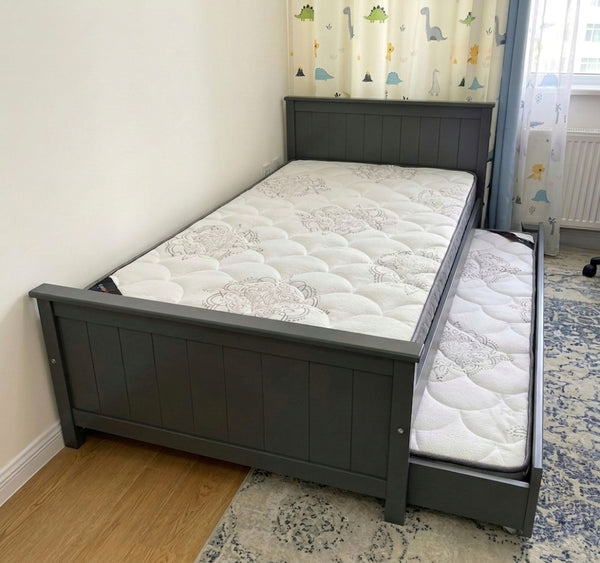 Gray bed frame with two mattresses in a room with a colorful curtain. Хүүхдийн ор, Классик загвар