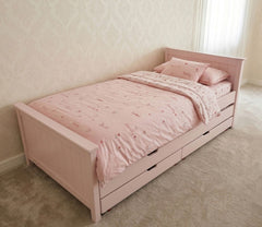 Pink children's bed with bedding in a room setting