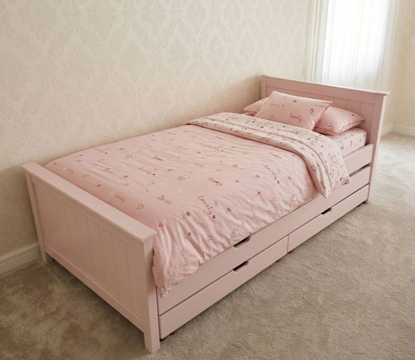 Pink children's bed with bedding in a room setting