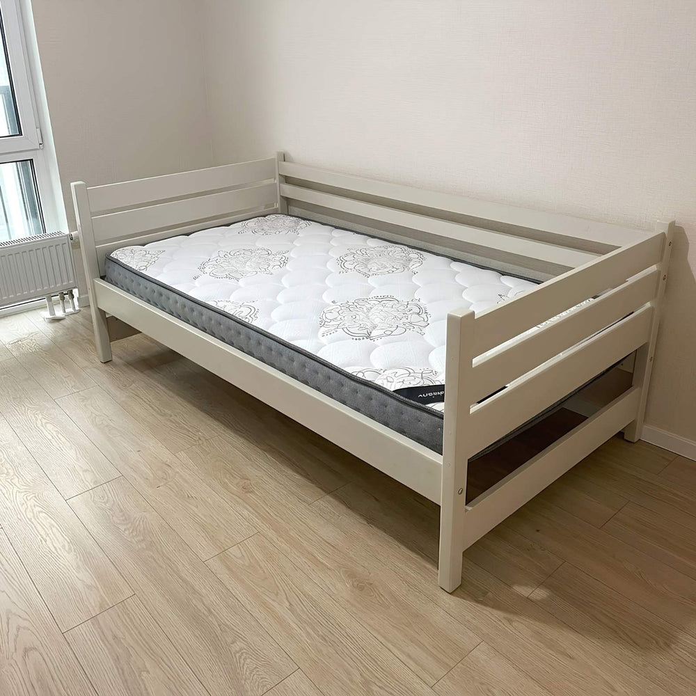 White wooden bed frame with mattress on a wooden floor.
